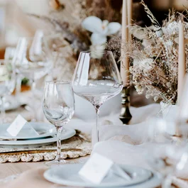 Eleganter gedeckter Tisch mit Kerzen und Trockenblumen für festliches Essen